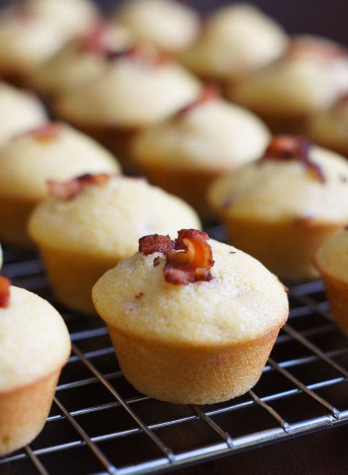 Close up of a cornbread muffin topped with bacon.