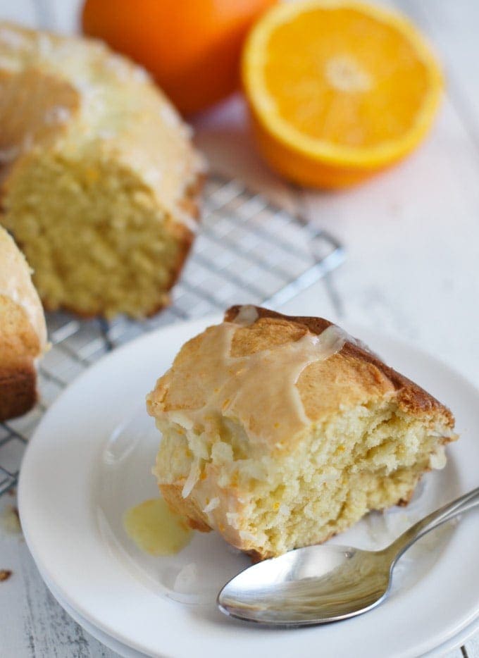 A slice of cake on a white plate with a spoon.