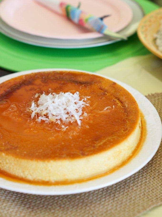 Coconut Flan served in a round platter topped with sweetened coconut flakes