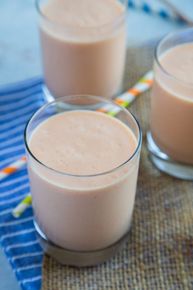 Papaya milkshake (batido de lechosa) served in three glasses and straws on the side.