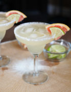 A grapefruit lime margarita in a glass with a salted rim.