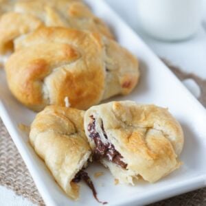 A plate of smores crescent rolls with one broken in half.