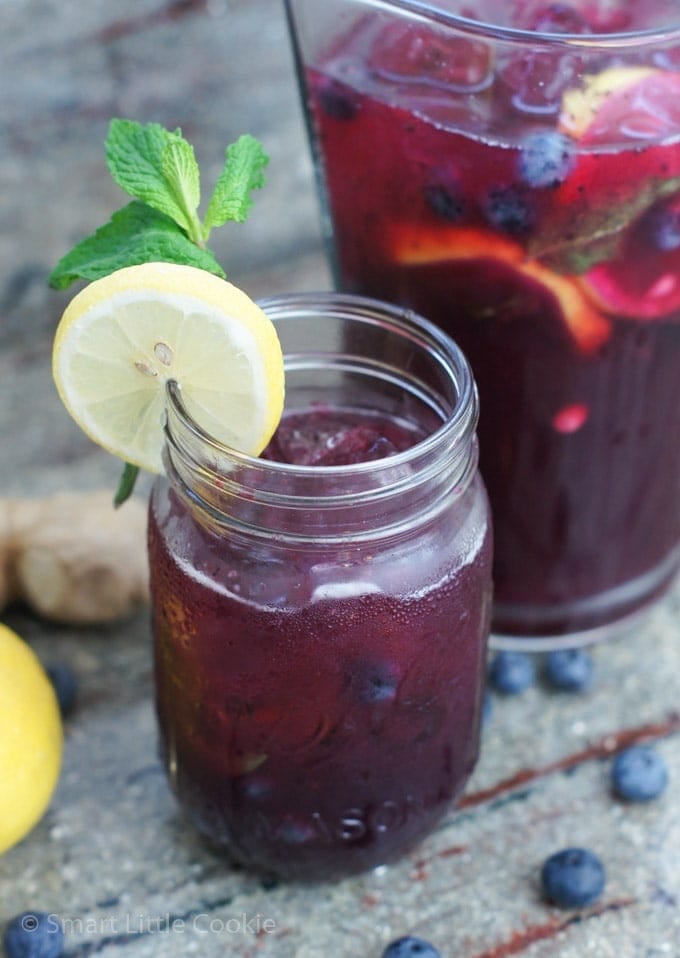 Blueberry ginger lemonade in a jar garnished with a slice of lemon.