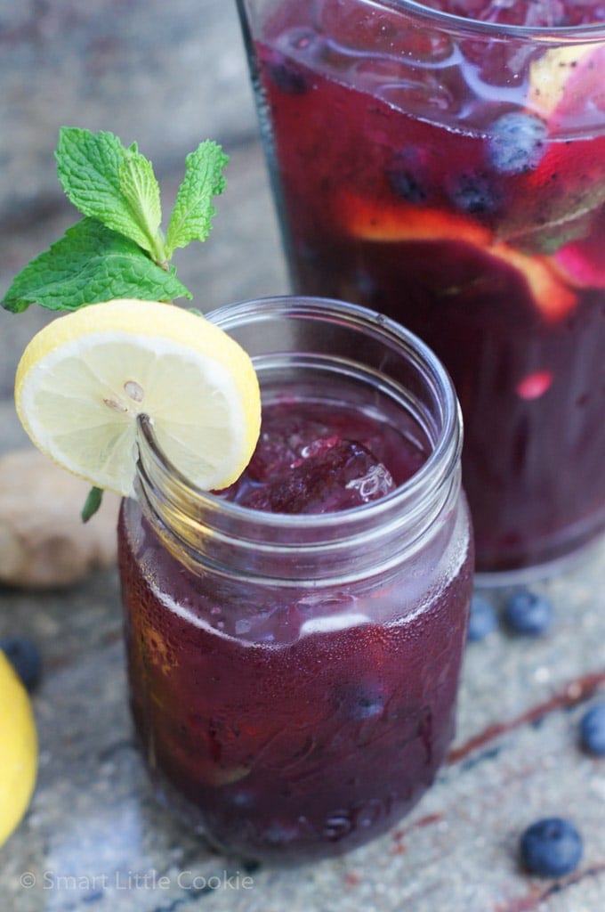 A ginger blueberry lemonade garnished with fresh mint and a lemon slice.