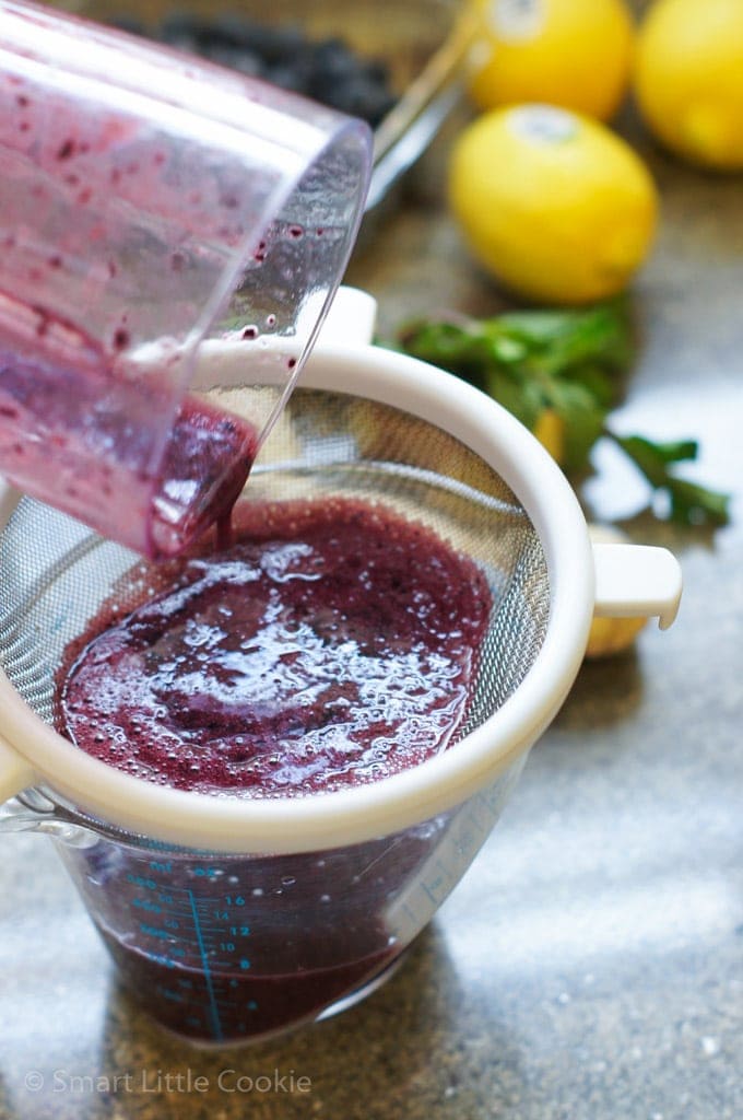 Passing the blended ingredients through a fine mesh sieve.