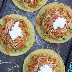 Overhead shot of four tostadas with chipotle chicken topping.