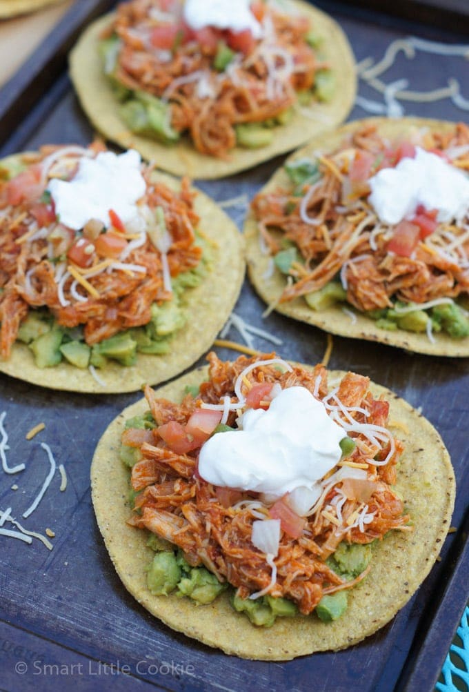 Close up of the shredded chicken topping on top of four tostadas.