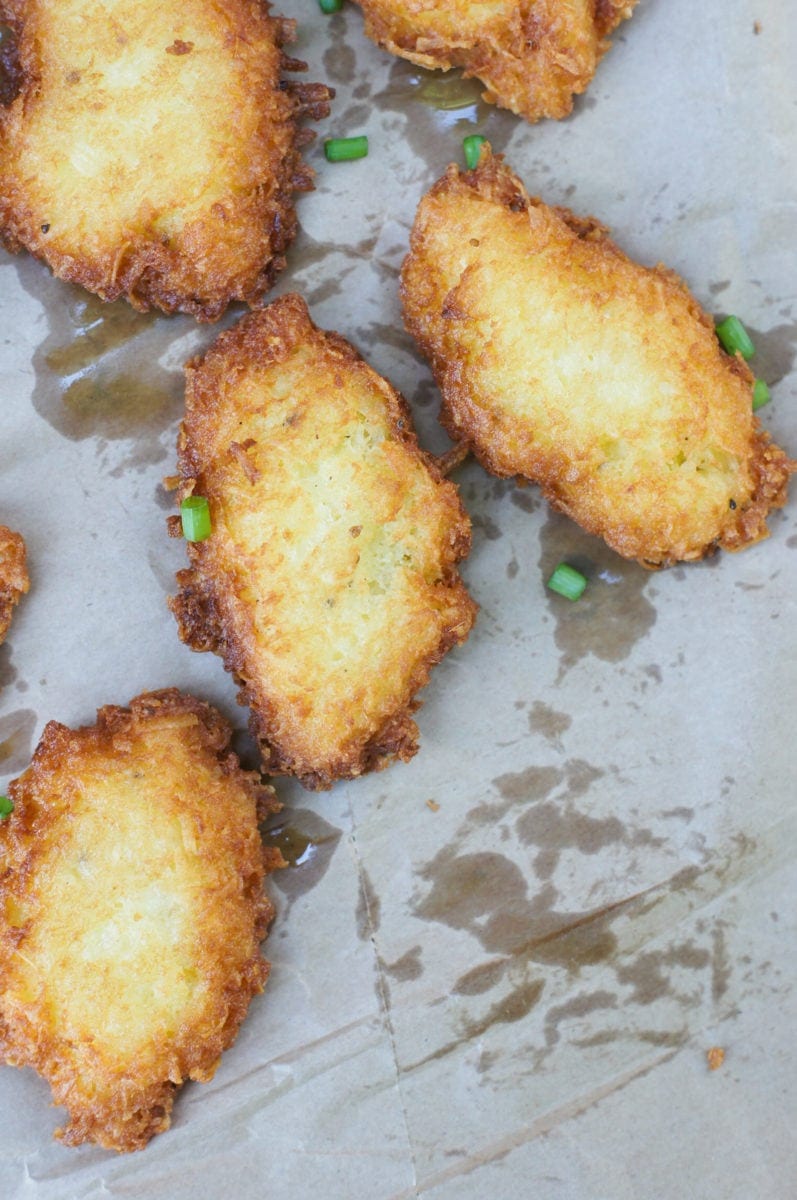 Four yuca fritters garnished with some fresh chives.
