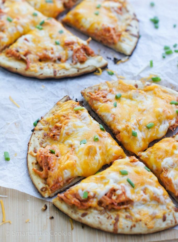 Two buffalo chicken pizzas garnished with fresh chives.