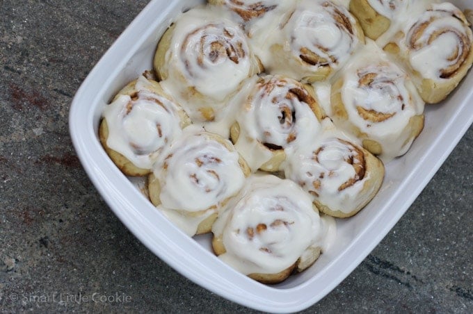 Cinnamon rolls in a baking dish glazed with icing.