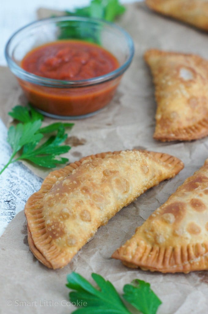 Empanadas de pizza de peperoni servidas al lado de una salsa