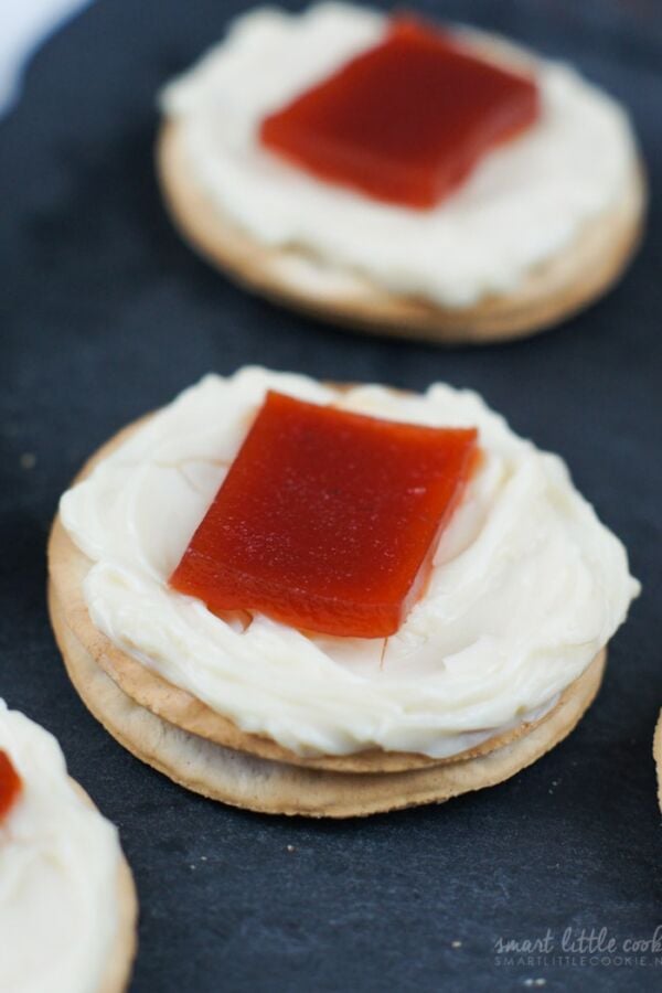A cracker topped with cream cheese and a piece of guava.