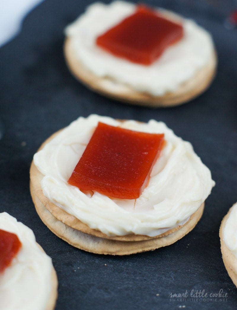 A cracker topped with cream cheese and a piece of guava.