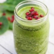 Green coconut and pomegranate smoothie in a glass jar.