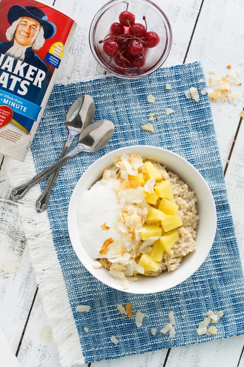 Pineapple and coconut oatmeal served in a bowl on a blue cloth.