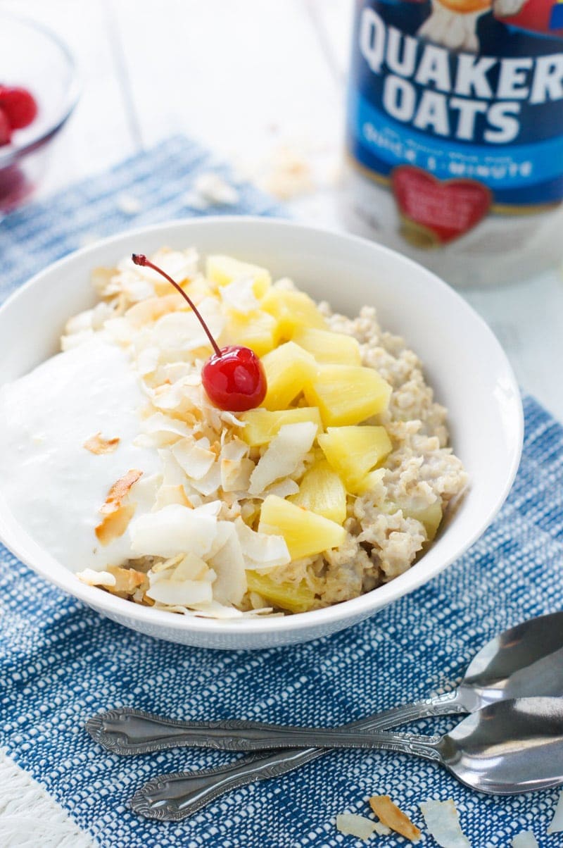 Pina colada oatmeal in a bowl and garnished with a cherry.