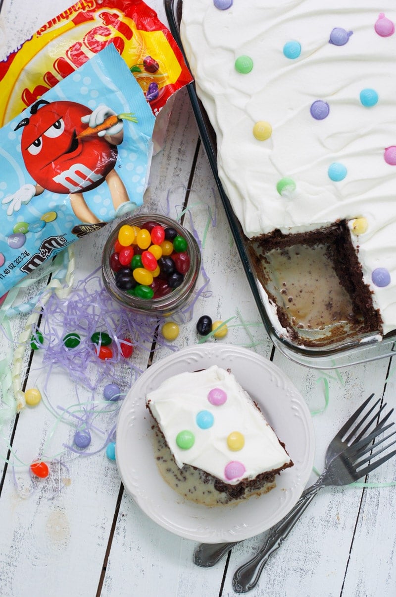 The chocolate tres leche cake in a baking dish with a square served on a plate.