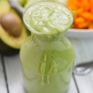 A glass bottle filled with avocado cilantro dressing.