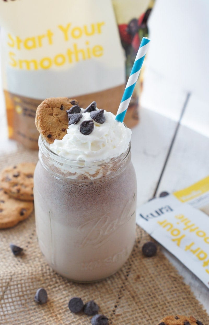 A smoothie in a glass jar with a striped straw.