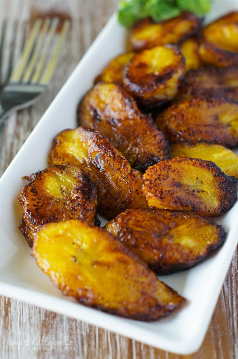 fatias de banana doce frita dourada (Platanos Maduros Fritos) servidas em um prato branco. 