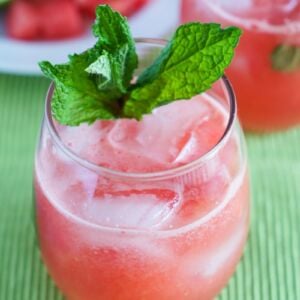 Watermelon Agua fresca in a glass with ice and a sprig of mint.