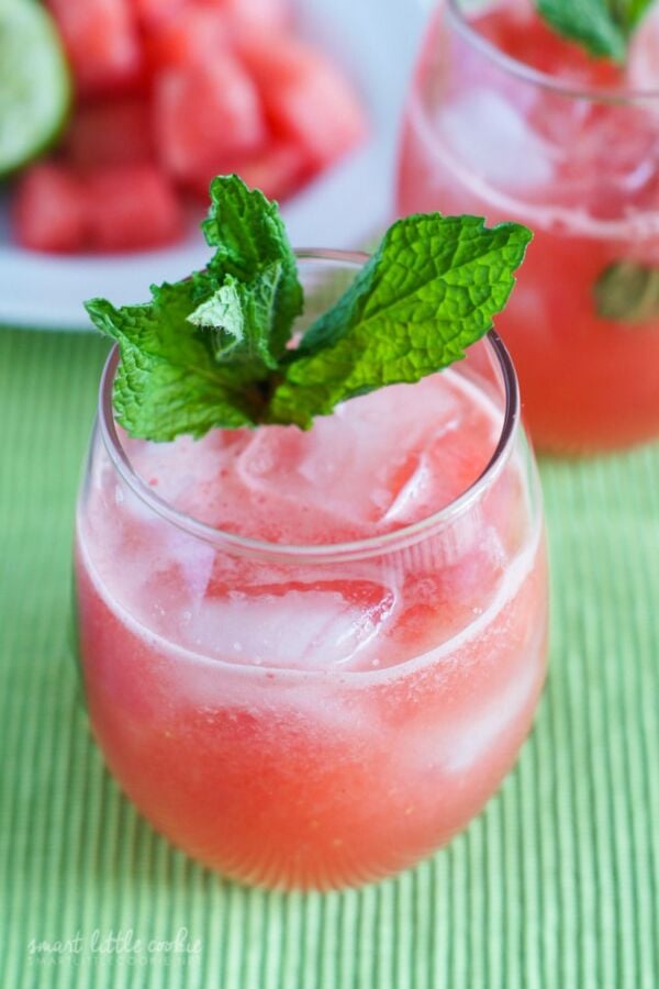 Watermelon Agua fresca in a glass with ice and a sprig of mint.