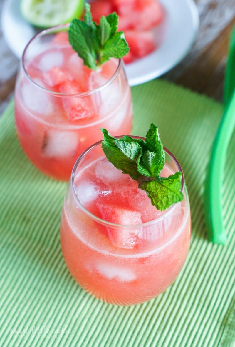 Two glasses of watermelon agua fresca with ice cubes and fresh mint.