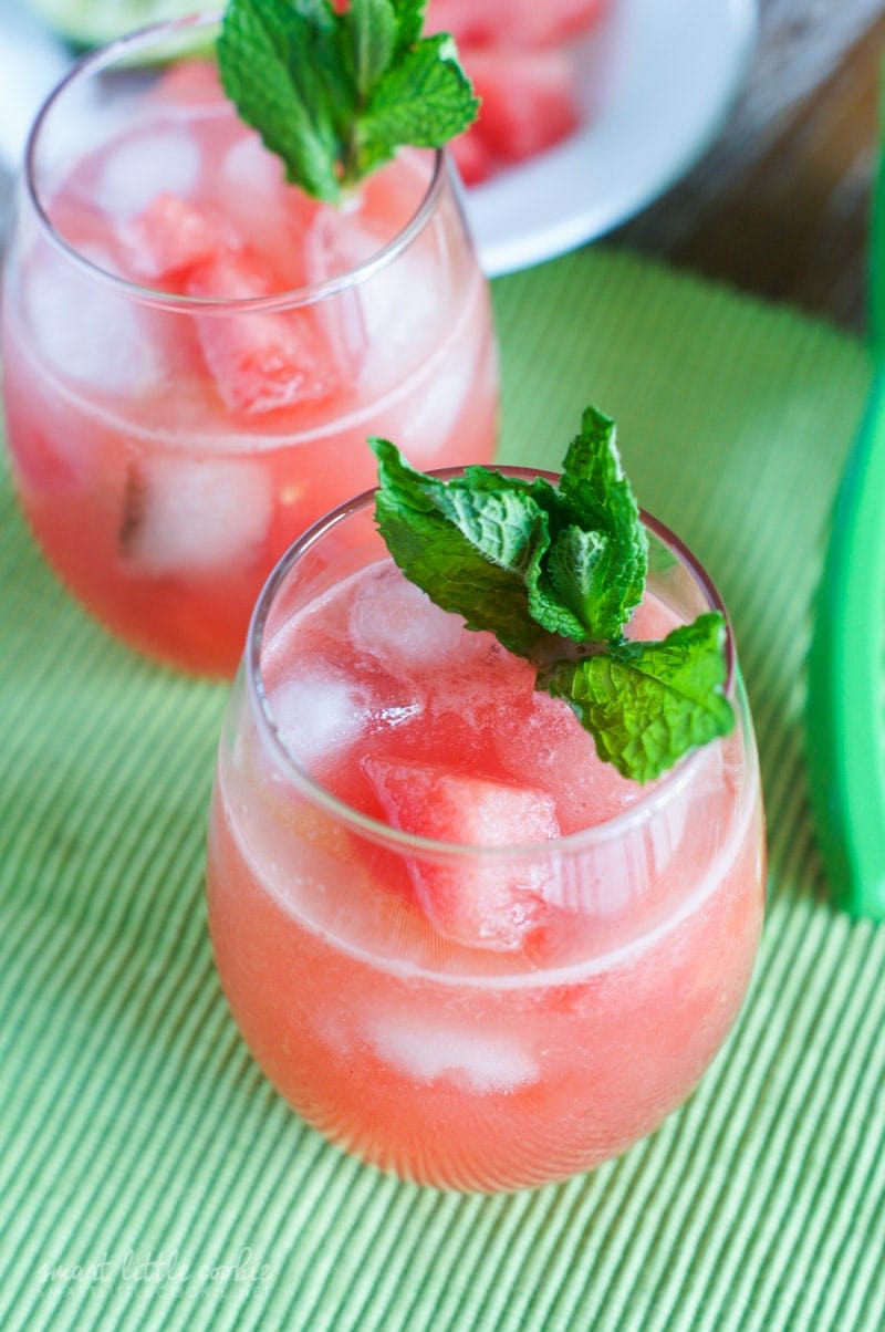 A glass of pink drink garnished with fresh mint.