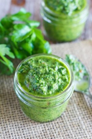Close up of the sauce next to a bunch of fresh herbs.
