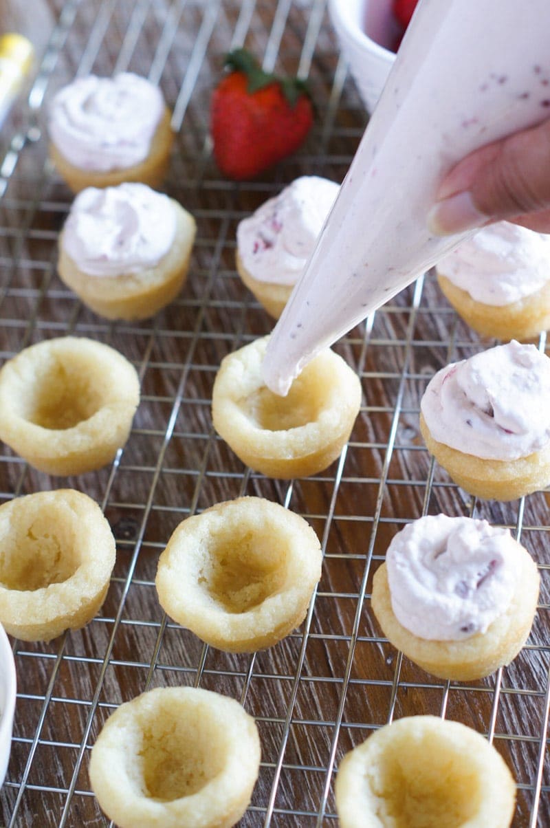 Piping the cheesecake filling into the cookie cups.