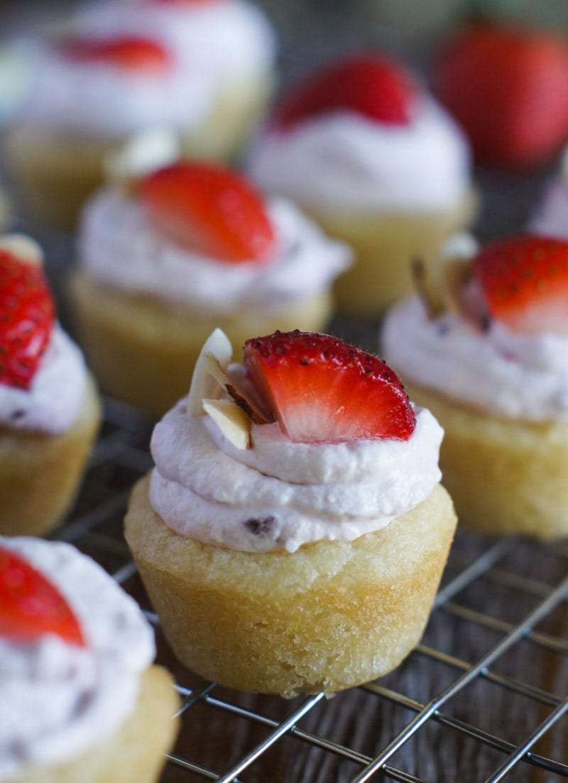 Close up of a cheesecake cookie cup topped with fresh sliced strawberries.