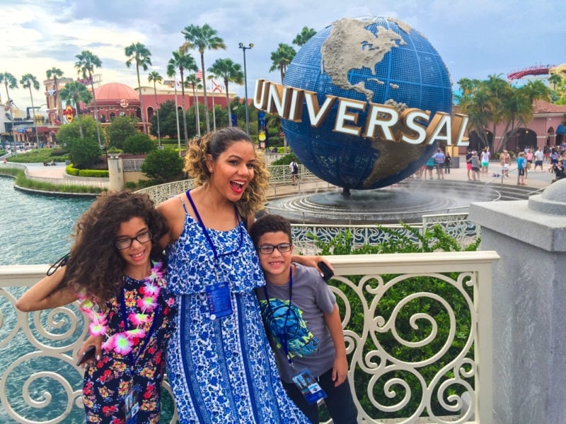 Three people standing in front of the Universal studios globe.