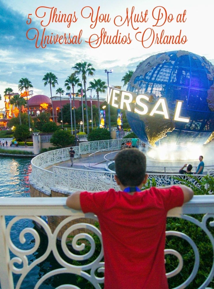 A boy standing in front of the Universal Studios globe.
