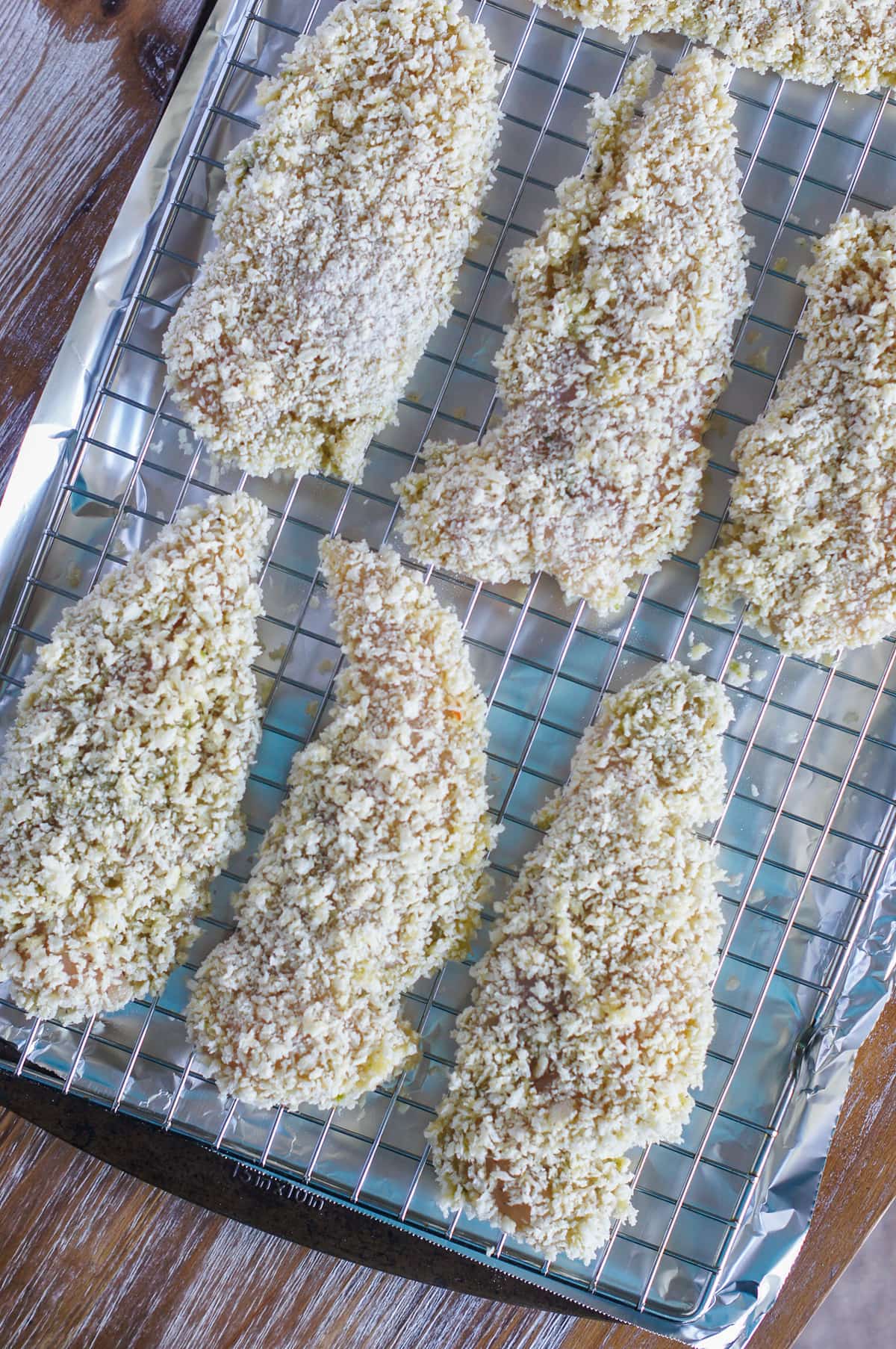 uncooked chicken tenders on a baking rack