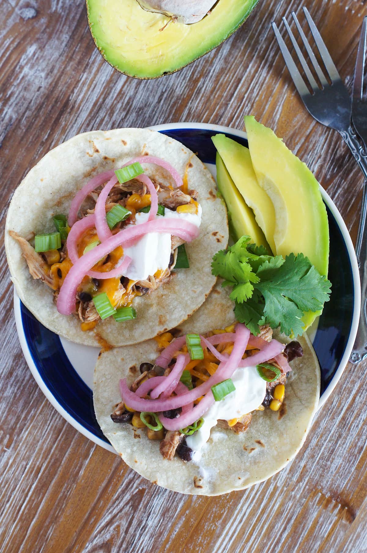Chicken Chili Tacos ~ The easiest, quickest and most flavorful tacos made with the best leftover slow cooker chicken chili, corn tortillas, avocados, pickled onions and sour cream. 
