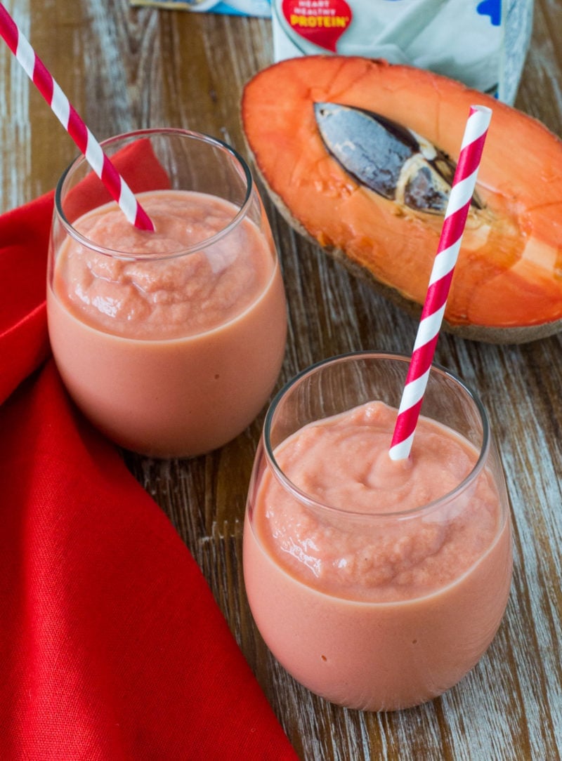 Two smoothies next to a fresh mamey fruit.