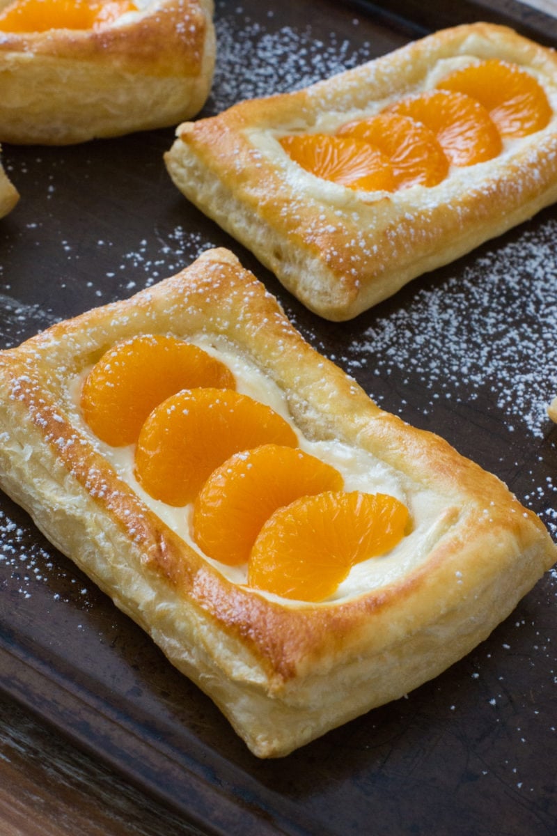 A pastelito topped with mandarin segments and cream cheese.