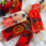 Overhead shot of different colored fruit popsicles sprinkled with spices.