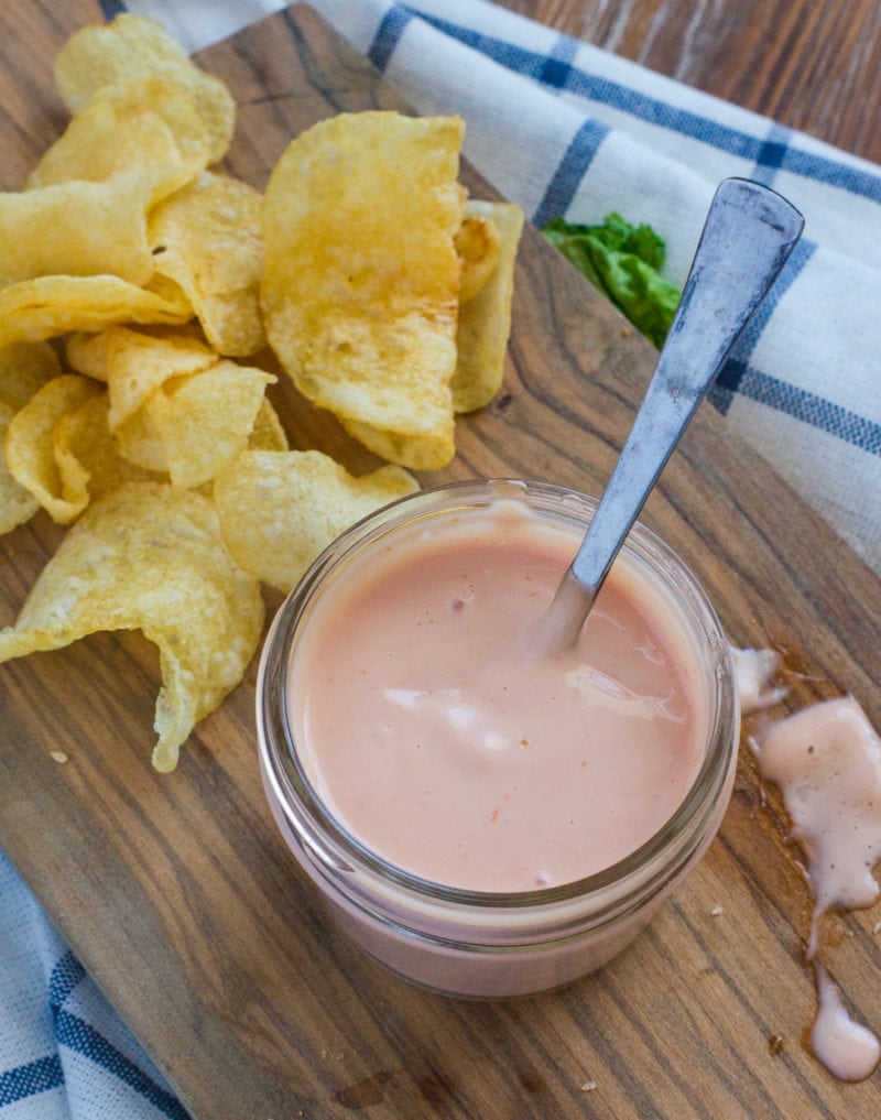 dipping sauce in a mason jar with potato chips on the side. 