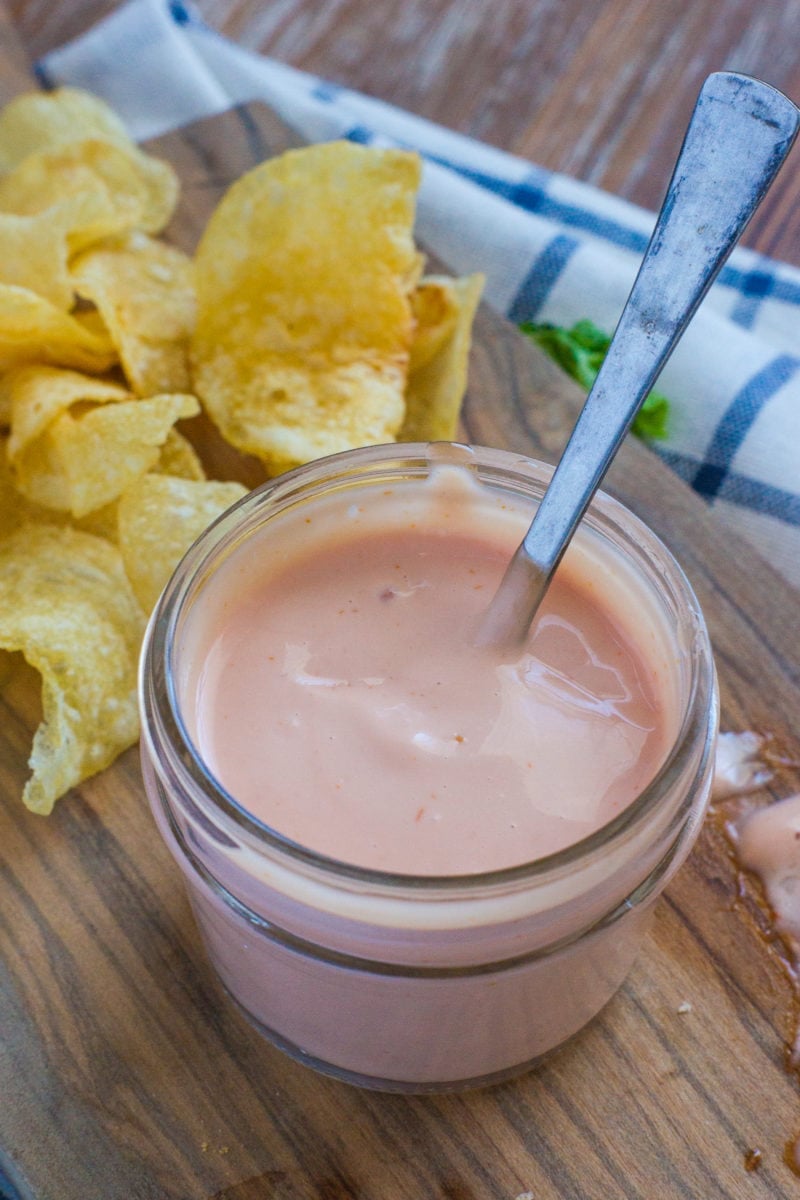 mayo ketchup sauce in a mason jar with potato chips on the side. 