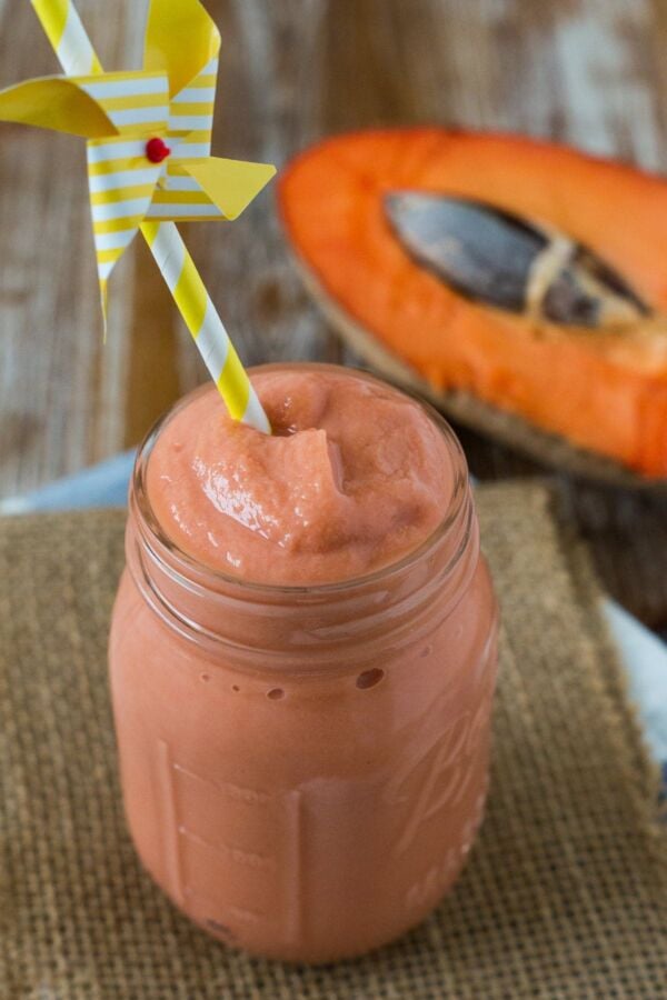 A mamey smoothie served in a glass jar with a straw.
