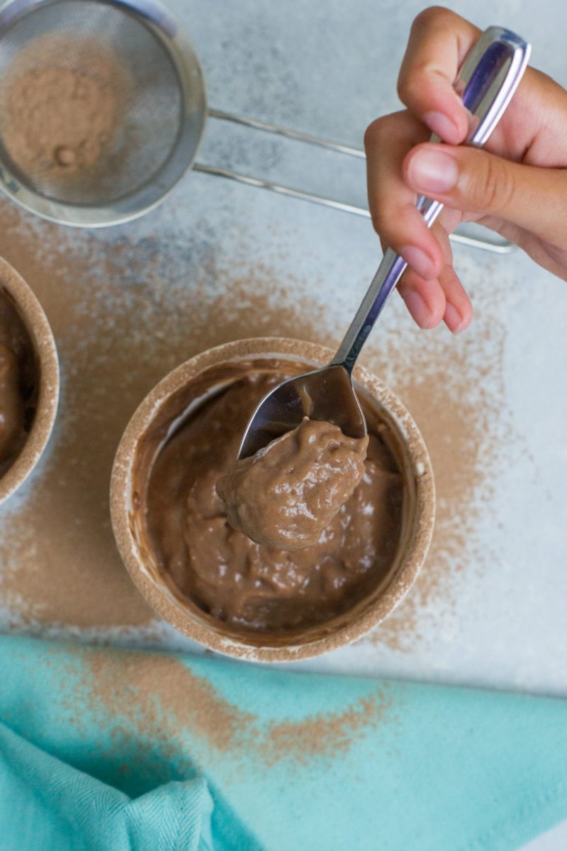 Overhead shot of a pudding being eaten with a spoon.