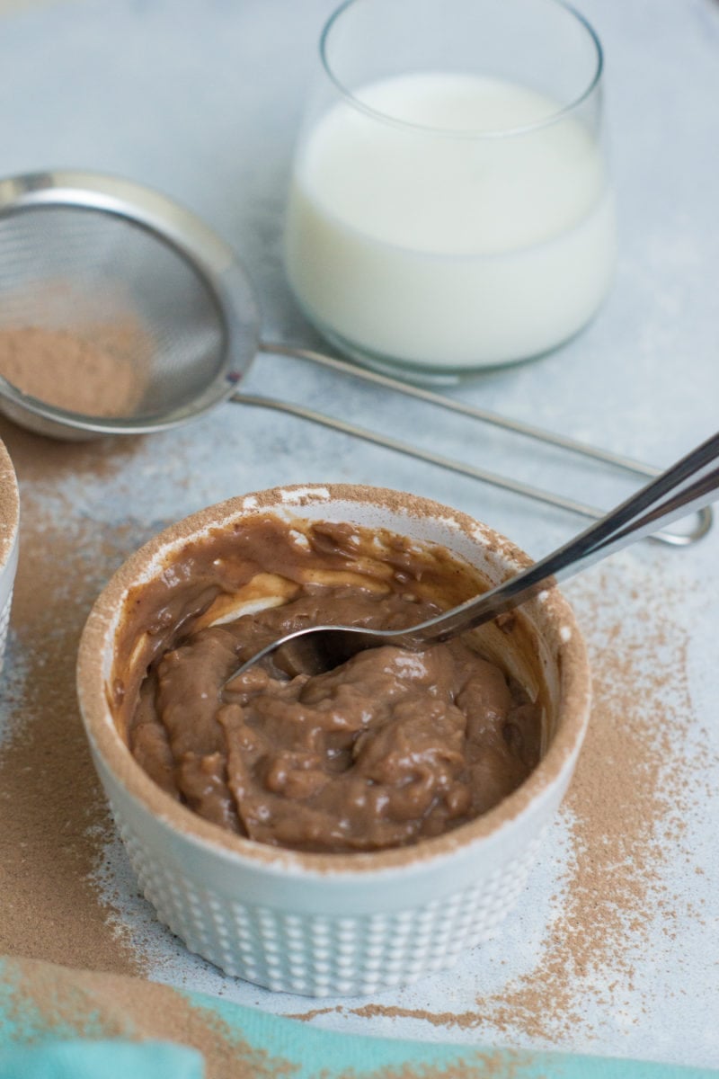 Close up of the chocolate pudding in a small ramekin with a spoon.