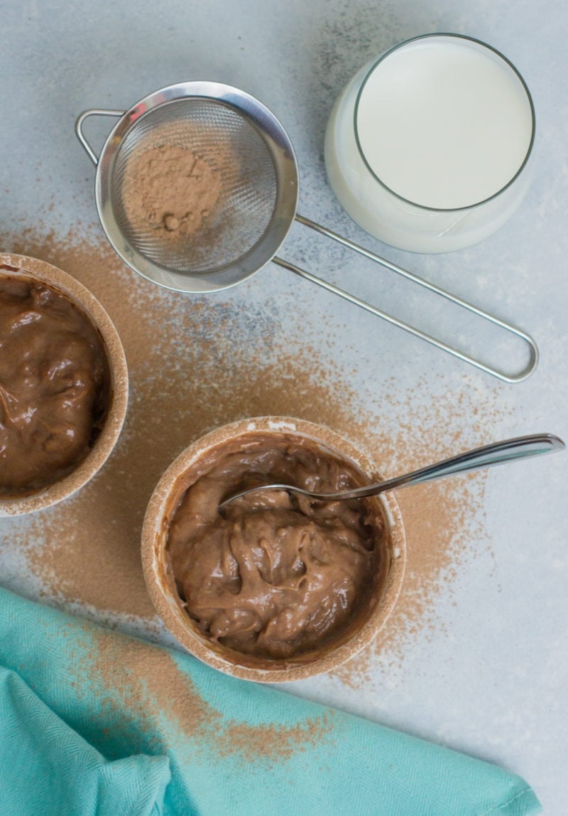 Pudín de Chocolate al lado de cocoa y un vaso de leche