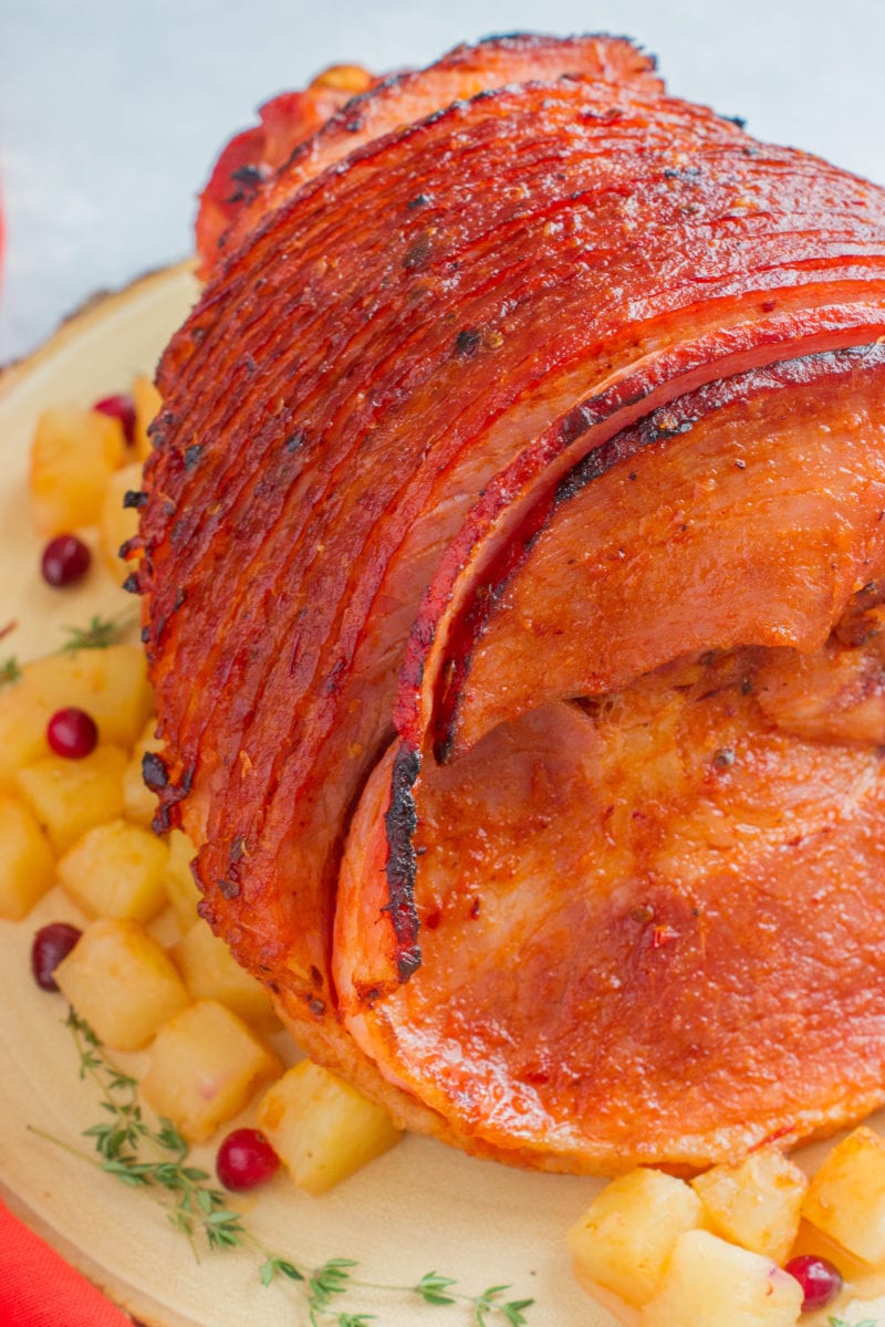 Toma de cerca de Jamón Glaseado adornado con piña en un plato de madera