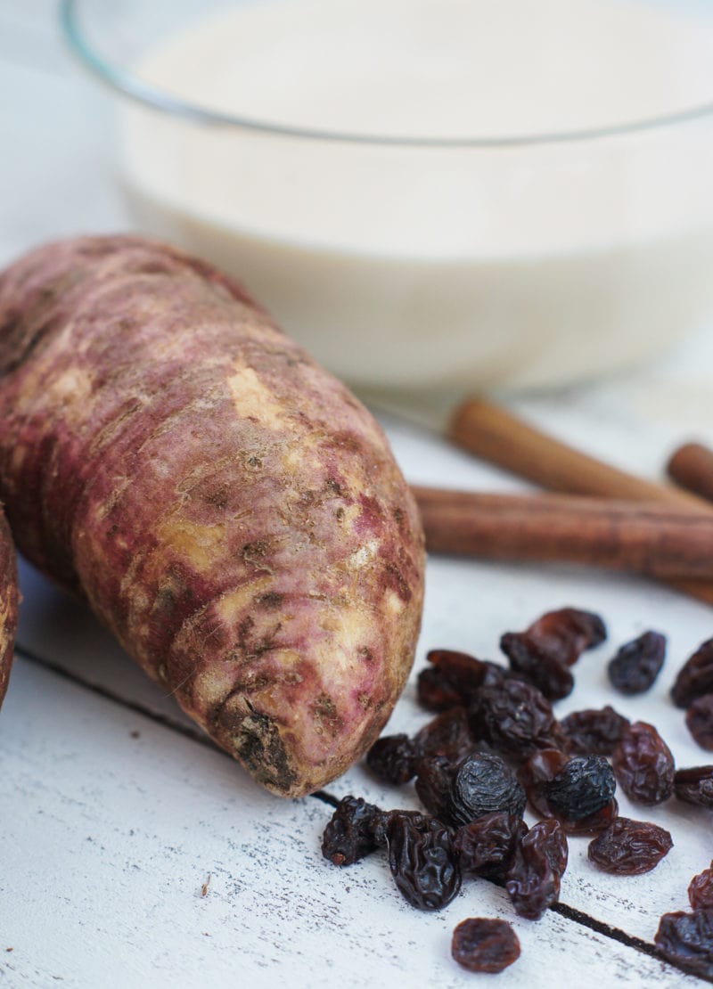 A sweet potato, raisins and cinnamon sticks.