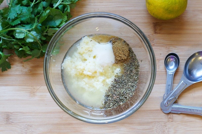 Chopped garlic in a bowl with other herbs and seasonings