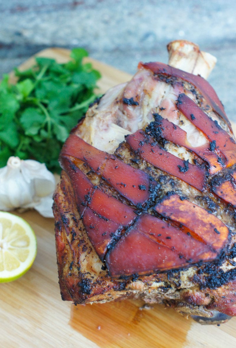 Roasted pork shoulder on a wooden chopping board.
