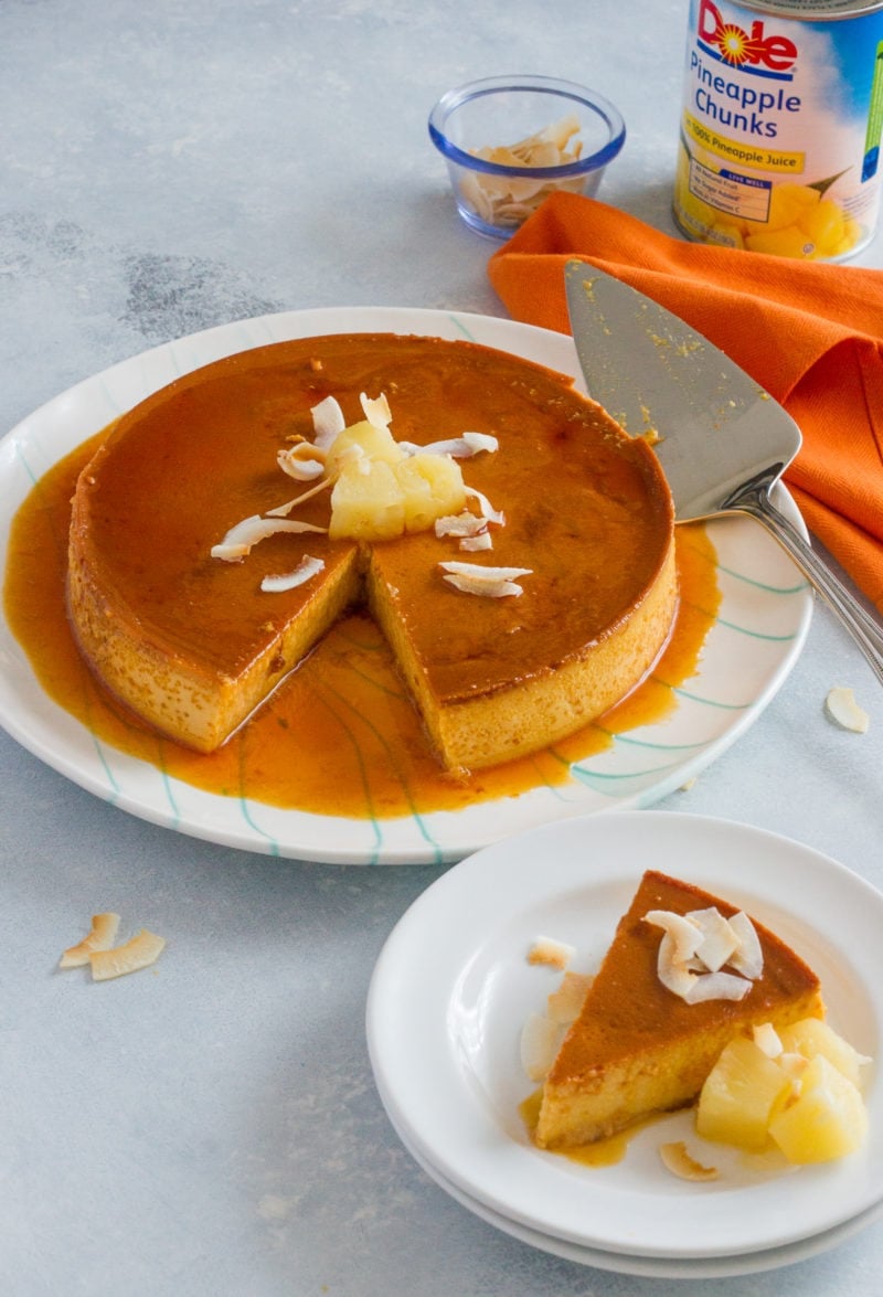 Pineapple flan on a serving plate with a cake slice.