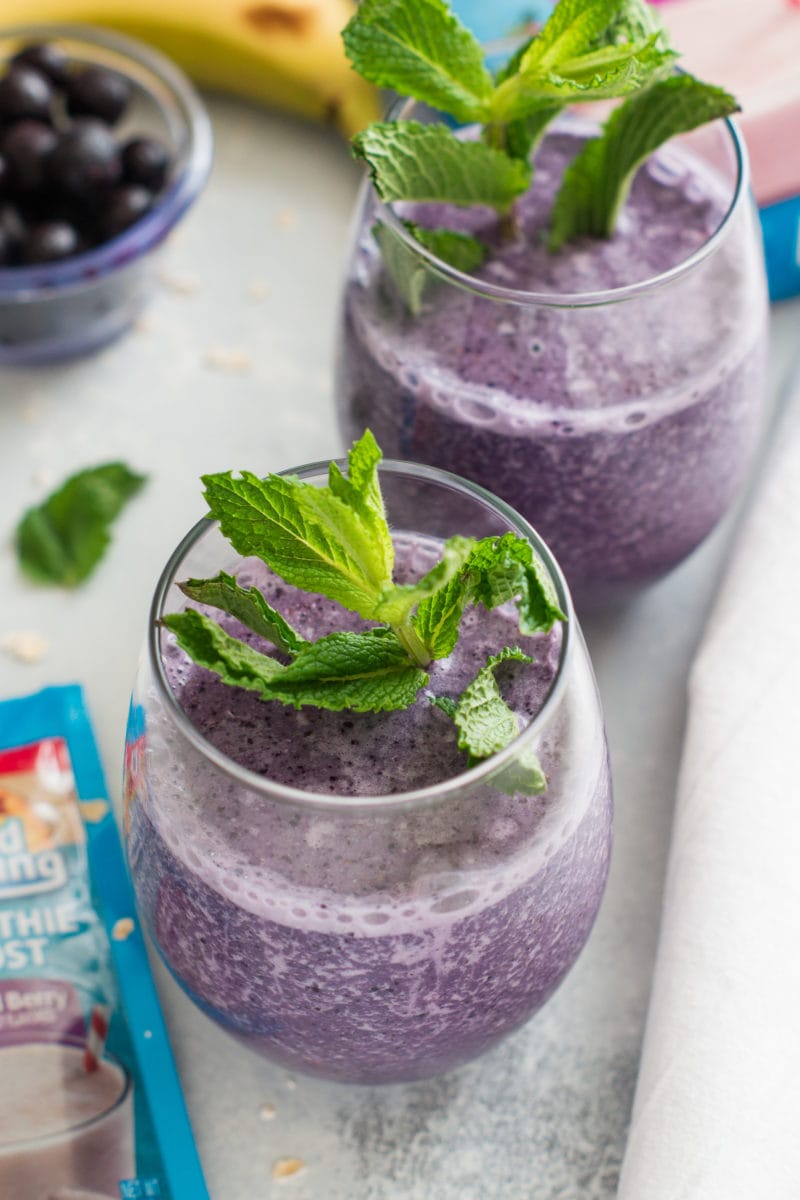 Two smoothies in glasses garnished with fresh mint.